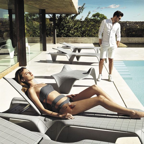Image of woman lying back on Vondom F3 contemporary plastic sun lounger on sunny poolside