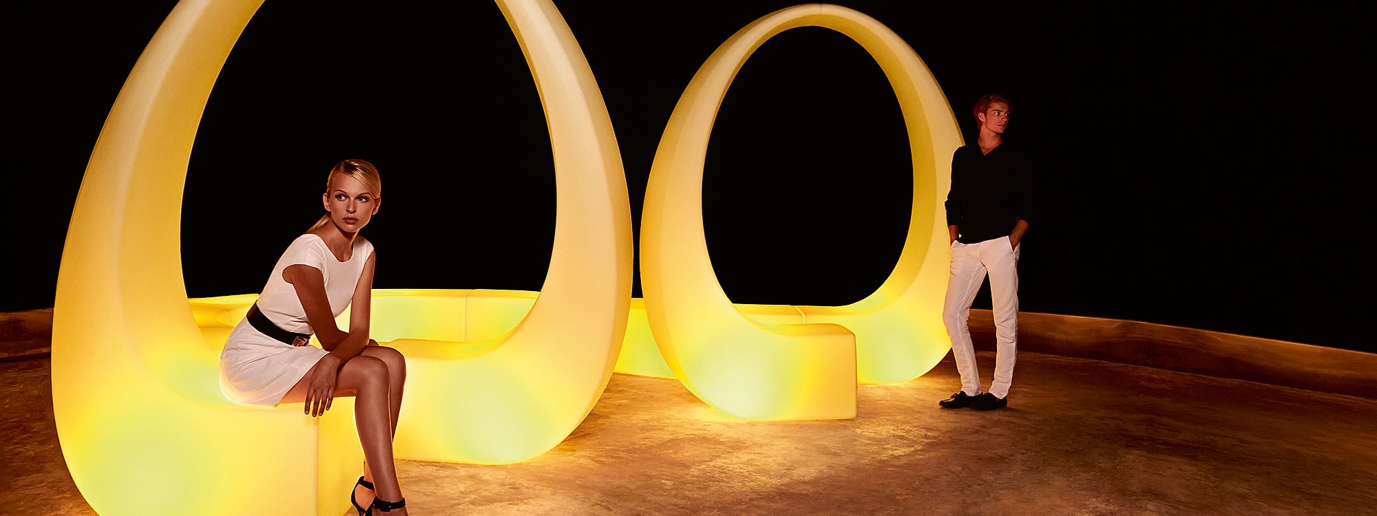 Nighttime image of illuminated Vondom AND modular bench with spatial design evocative of spinning DNA helix