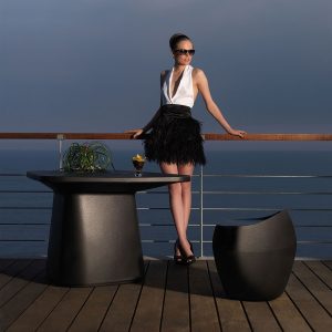 Image of woman leant on railings next to Vondom Moma small garden table and stool
