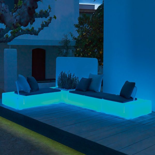 Nighttime image of Kes garden sofa by Vondom lit with blue LED lighting inside the furniture