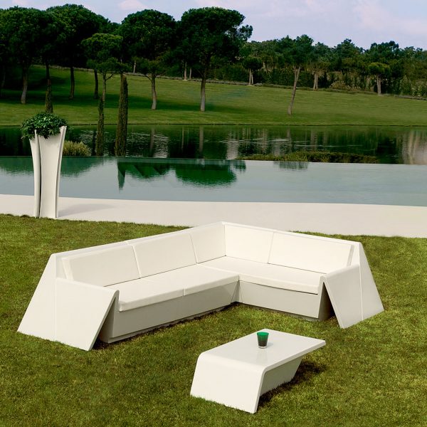 Image of Vondom Rest white modern garden corner sofa on lawn, with lake and trees in the background