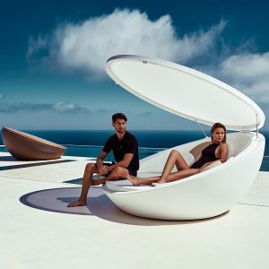 Image of couple sat inside Vondom Ulm modern outdoor daybed with canopy