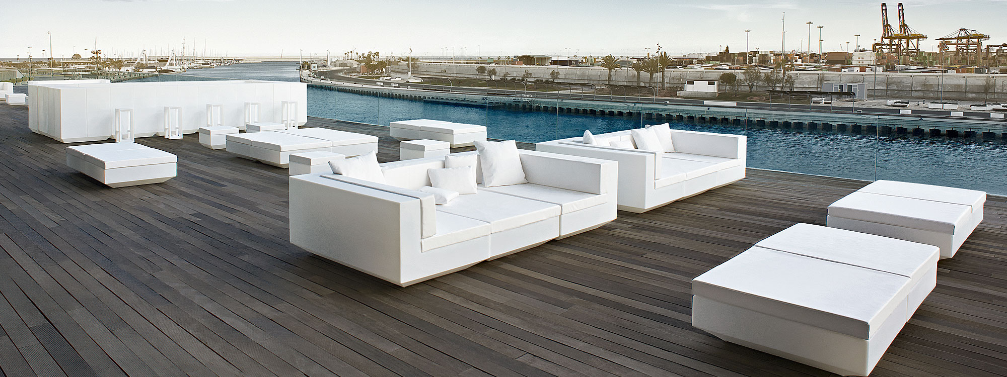 Image of Vondom Vela white garden lounge furniture and modular bar furniture on decked sun terrace in Spanish port