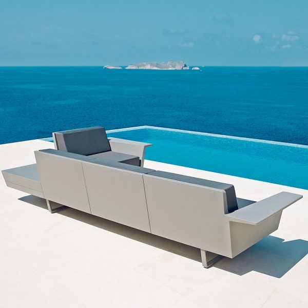 Image of rear of Vondom Delta modern garden sofa on poolside terrace, with blue sea and sky in the background