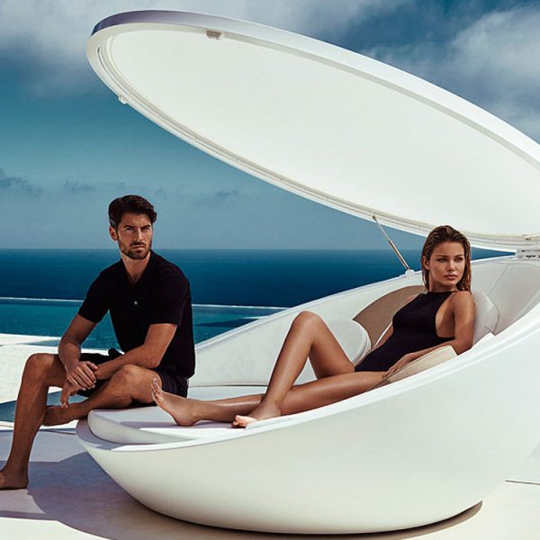 Image of pair of young dudes sat inside Vondom Ulm futuristic white garden furniture with retractable sun canopy