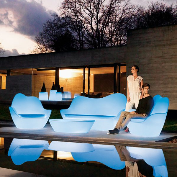 Image of Vondom Sabinas plastic outdoor sofas and lounge chairs at dusk with blue LED illumination