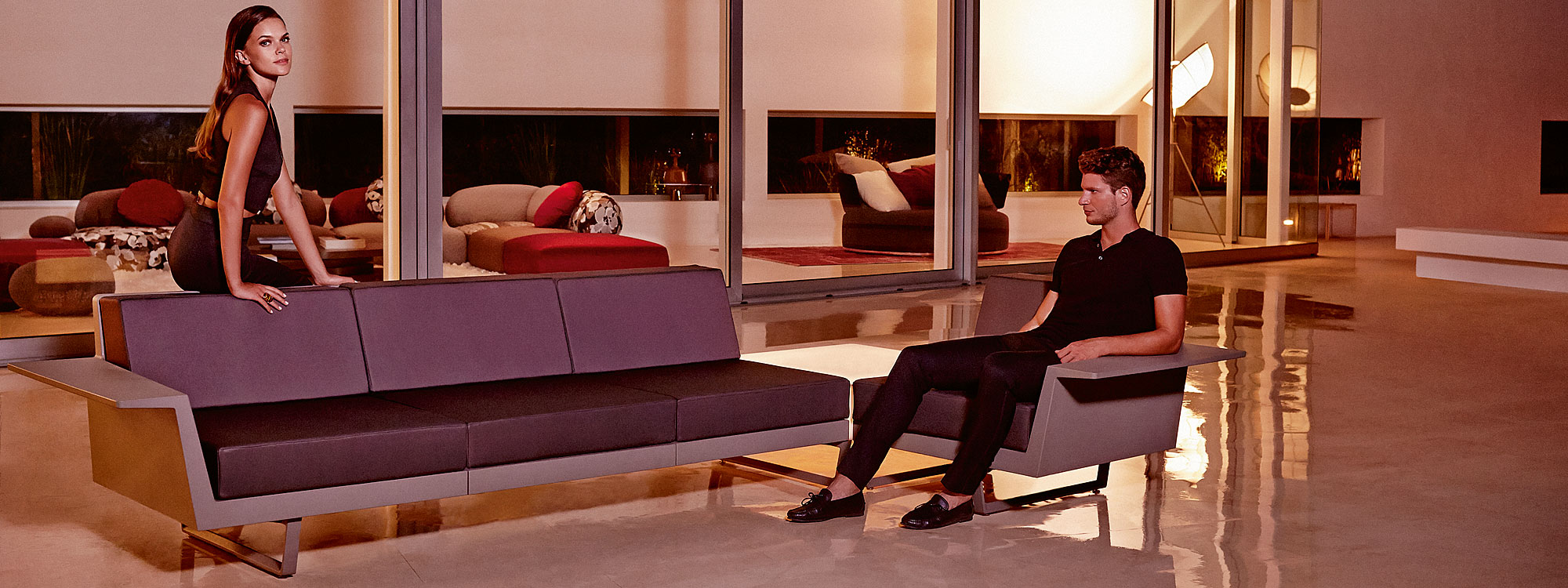 Nighttime indoor shot of Vondom Delta modern sofa on shiny polished concrete floor