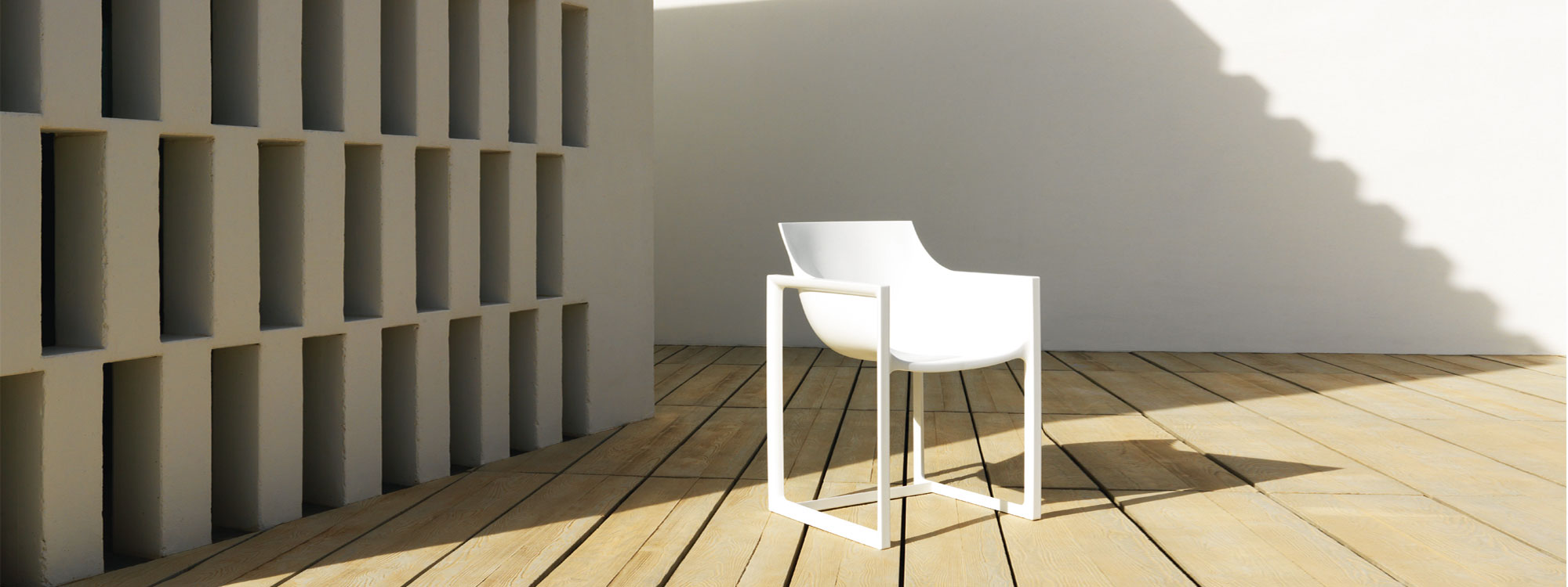 Image of white Wall Street injection molded contract chair by Vondom on sunny terrace