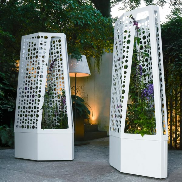 Image of pair of Flora Air planters on wheels with trellis, shown on outdoor terrace at dusk