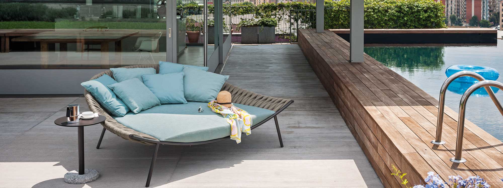 Image of RODA Arena daybed and Bernardo round side table on decked poolside