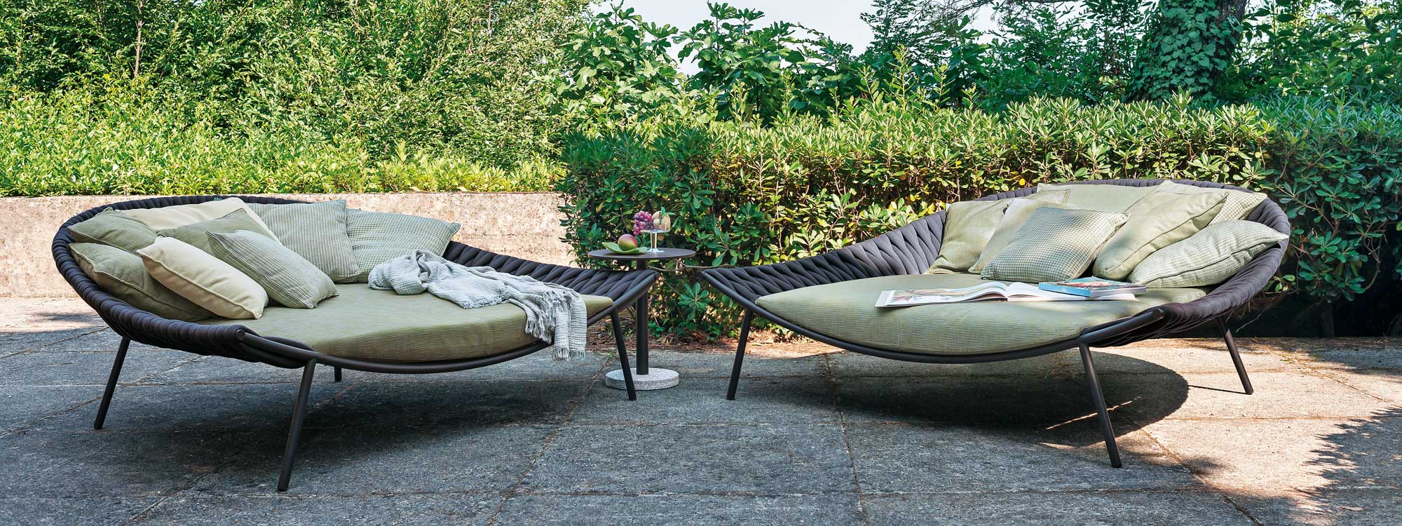 Image of pair of Arena minimalist garden daybeds by RODA, shown side to side on terrace, with Bernardo circular side table in the center