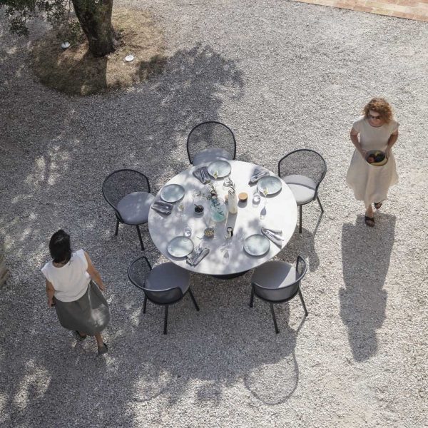 Image of aerial view of 5 Baza modern outdoor chairs around Branta circular garden table in light and shade on terrace