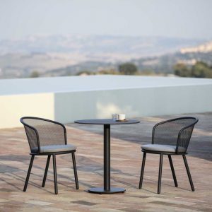 Image of anthracite colored Baza garden chairs and Branta outdoor bistro table with raised swimming pool and countryside in the background