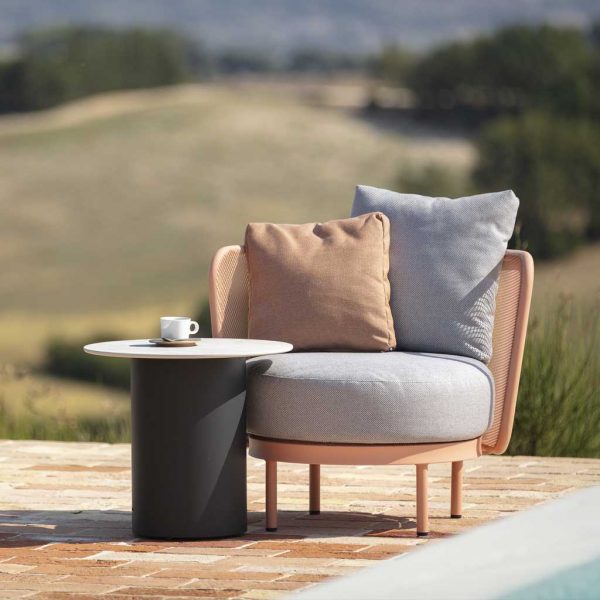 Image of Baza stainless steel garden lounge chair in salmon-pink finish with Branta modern garden side table with anthracite frame and pale grey ceramic table top