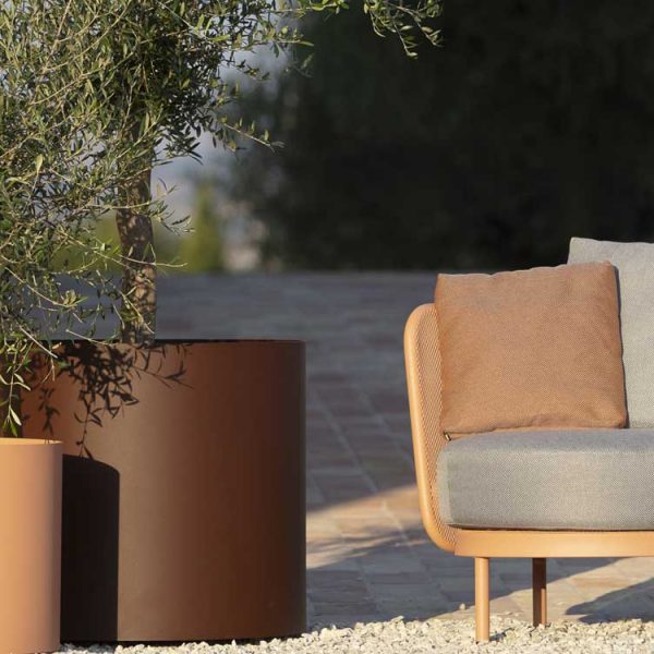 Image of salmon-pink Baza Club garden easy chair and rust-brown colored Verdi modern planters
