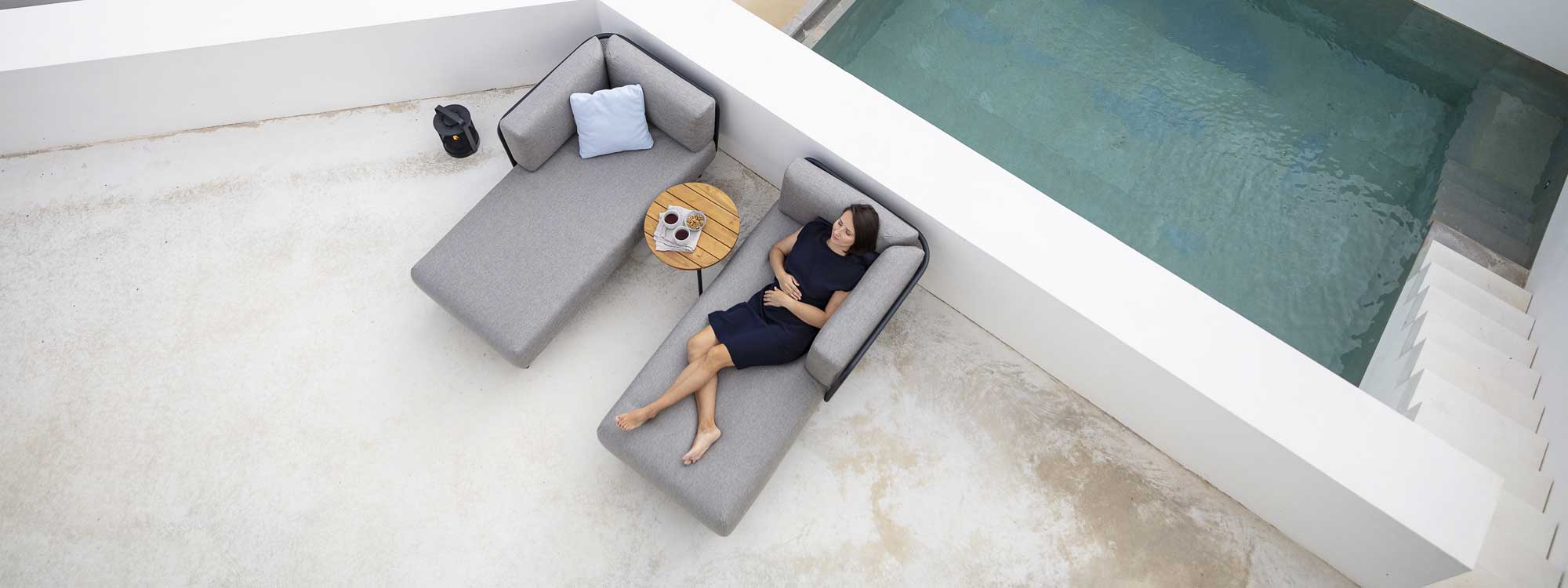 Birdseye view of woman reclining on Baza outdoor chaise longue