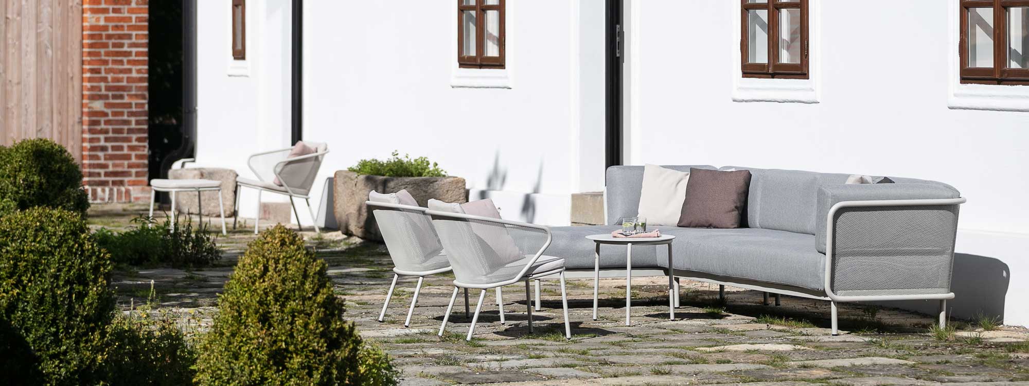 Image of Baza stainless steel garden sofa with Condor lounge chairs and Starling low tables on sunny terrace