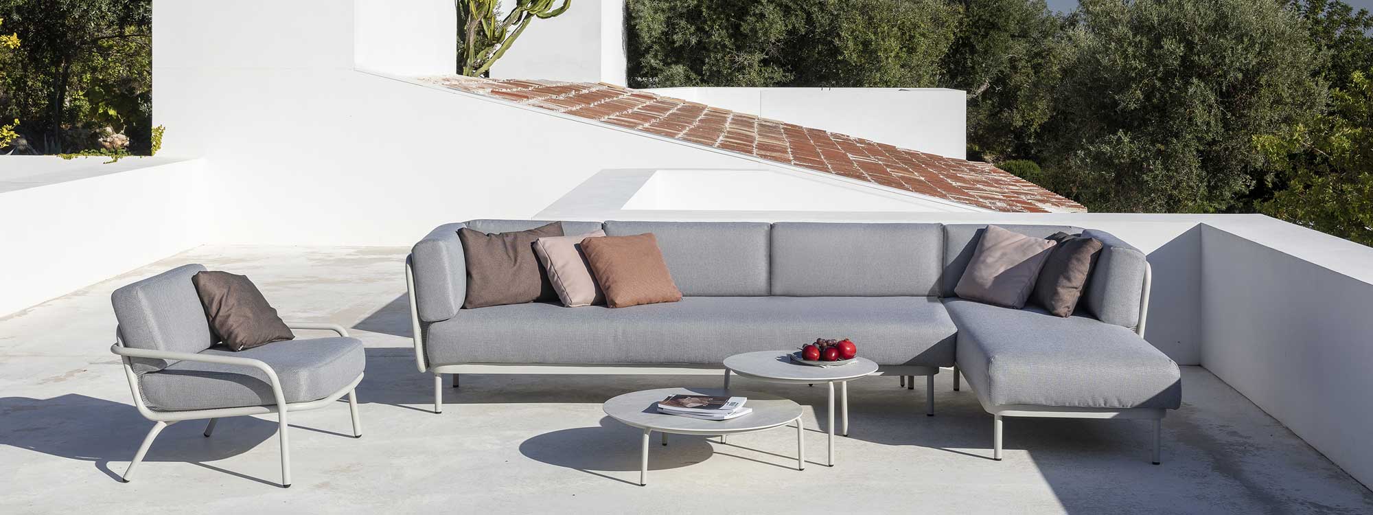 White Baza garden sofa and Starling longer chair & low tables on sizzling hot terrace
