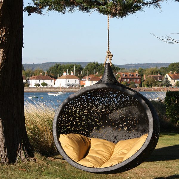 Image of Bios Mini chair swing by Unknown Nordic, suspended from cedar tree with Bosham Harbor in background