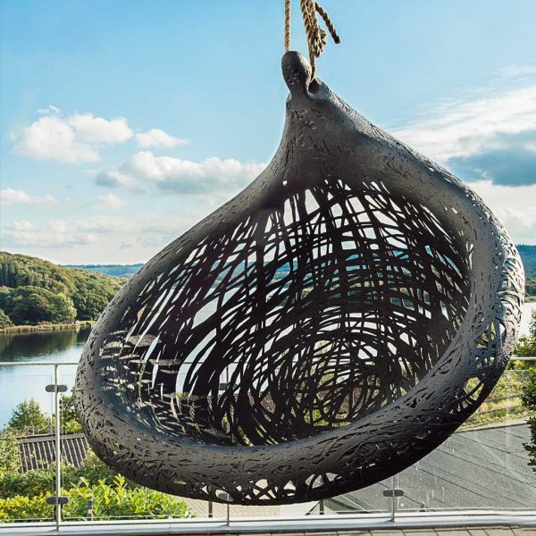 Image of Bios Lucid anthracite swing chair by Unknown Nordic, with lake and woodland in the background