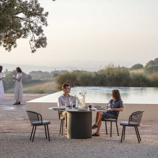 Branta circular garden dining set on sultry terrace in front of swimming pool and olive trees