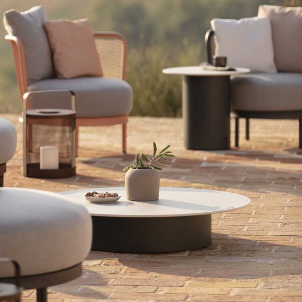 Branta round low table surrounded by Baza garden sofa set and Baza lounge chair on sunny terrace