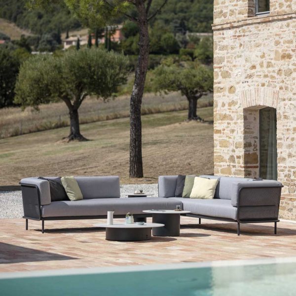 Branta exterior coffee tables and Baza garden corner sofa set on terrace with fir and olive trees in background