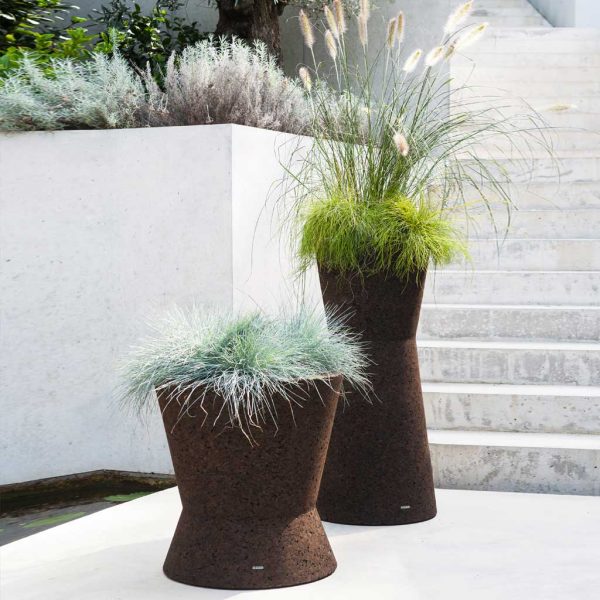 Pair of Bush On cork dark brown cork plant pots on polished concrete terrace