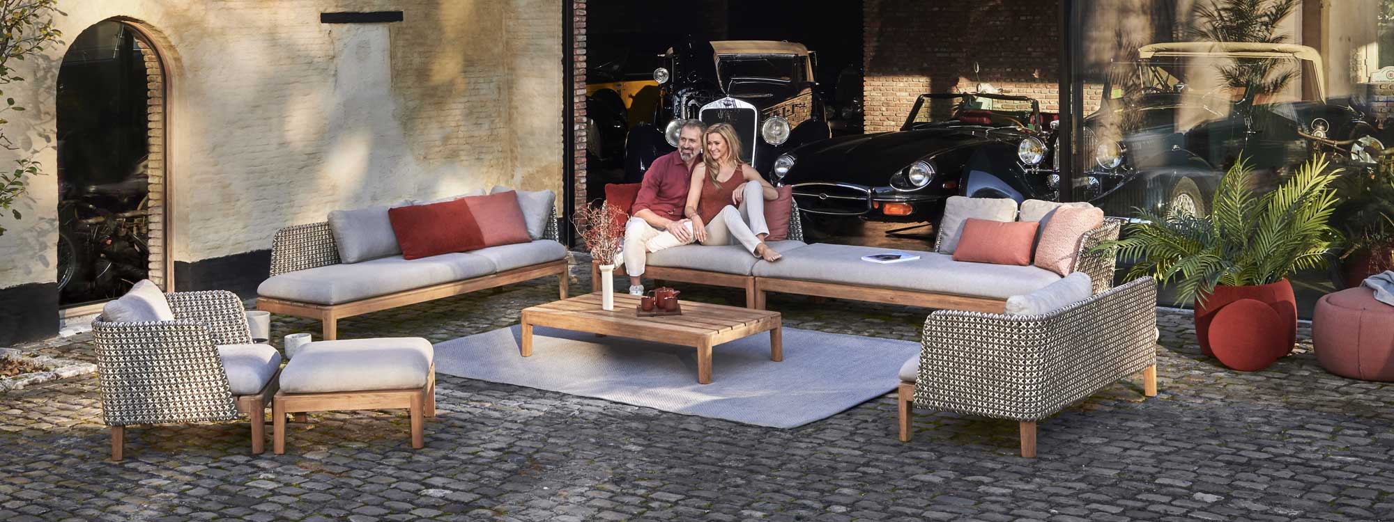 Image of Royal Botania Calypso garden lounge set with Kriss Kross woven backs, in cobbled courtyard with classic cars in background