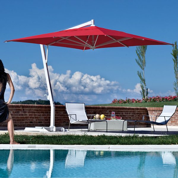 Image of Red Capri parasol by FIM over Coro furniture next to horizon swimming pool