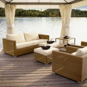 Image of natural rattan finish Chester garden sofa set by Cane-line, beneath pergola on lakeside