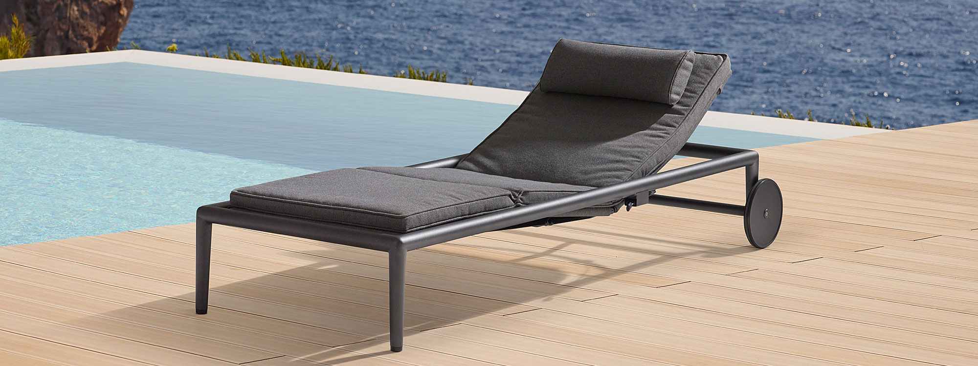 Image of grey Conic aluminium sun lounger with wheels by Cane-line, on decked poolside