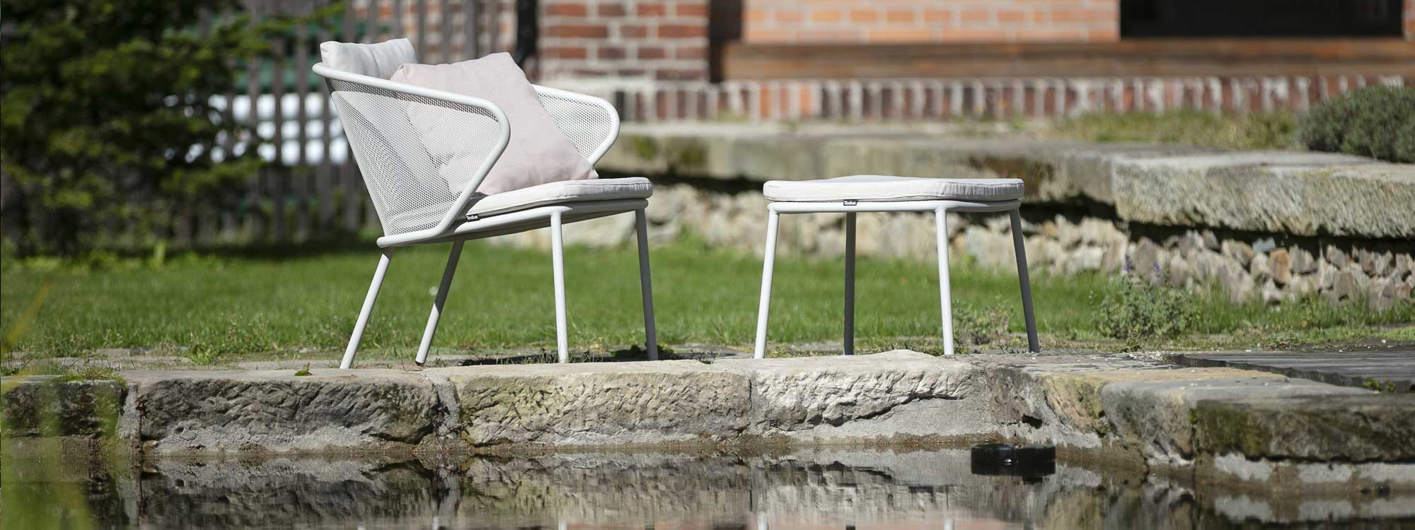 Image of White Condor garden relax chair & foot stool next to water