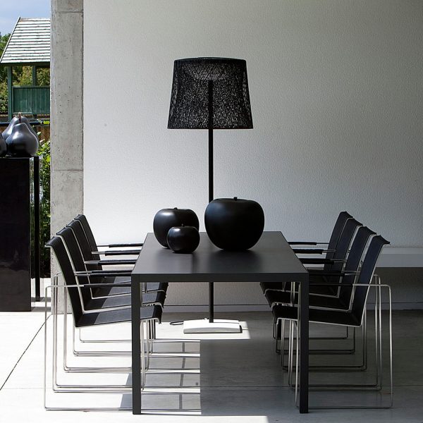 Image of Nimio modern black garden table with Sillon dining chairs either side, by FueraDentro