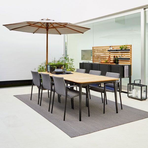 Image of Core garden table in lava grey with teak top and Core chairs in grey upholstery by Cane-line