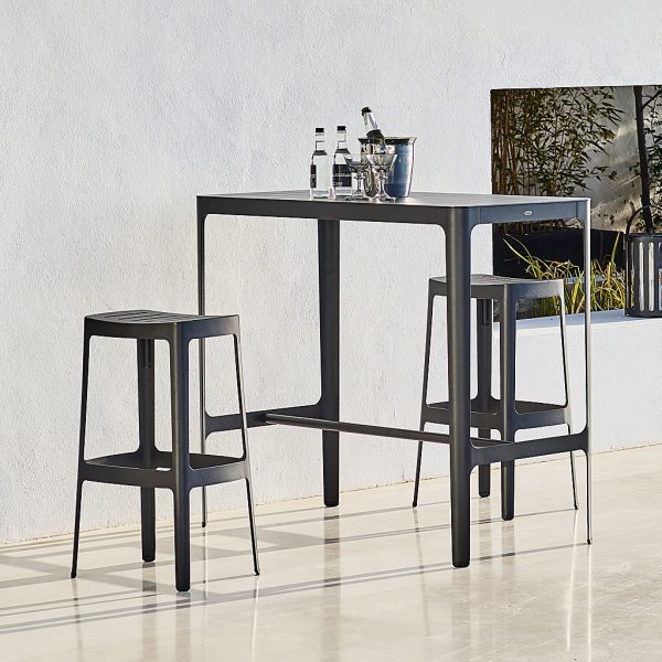 Image of pair of Cane-line Cut bar stools and outdoor bar table in black powder coated aluminum