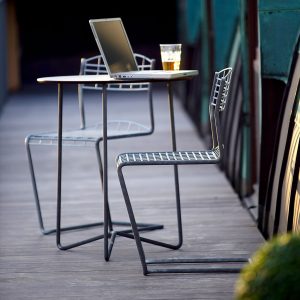 Image of pair of High Tech cantilever garden chairs and small circular table in galvanised steel, with computer and glass of beer placed on the table top
