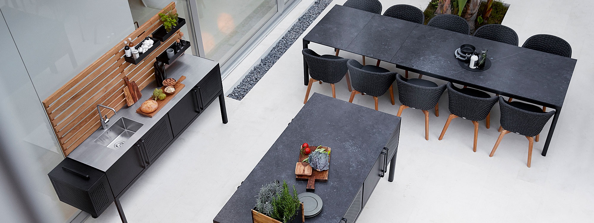 Image of Cane-line Drop extending table with black frame and black fossil ceramic top, together with Peacock chairs