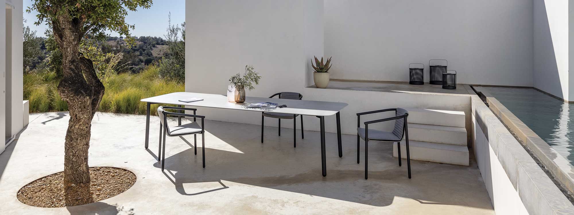 Duct Round garden chair with Starling exterior dining table on minimalist poured concrete terrace