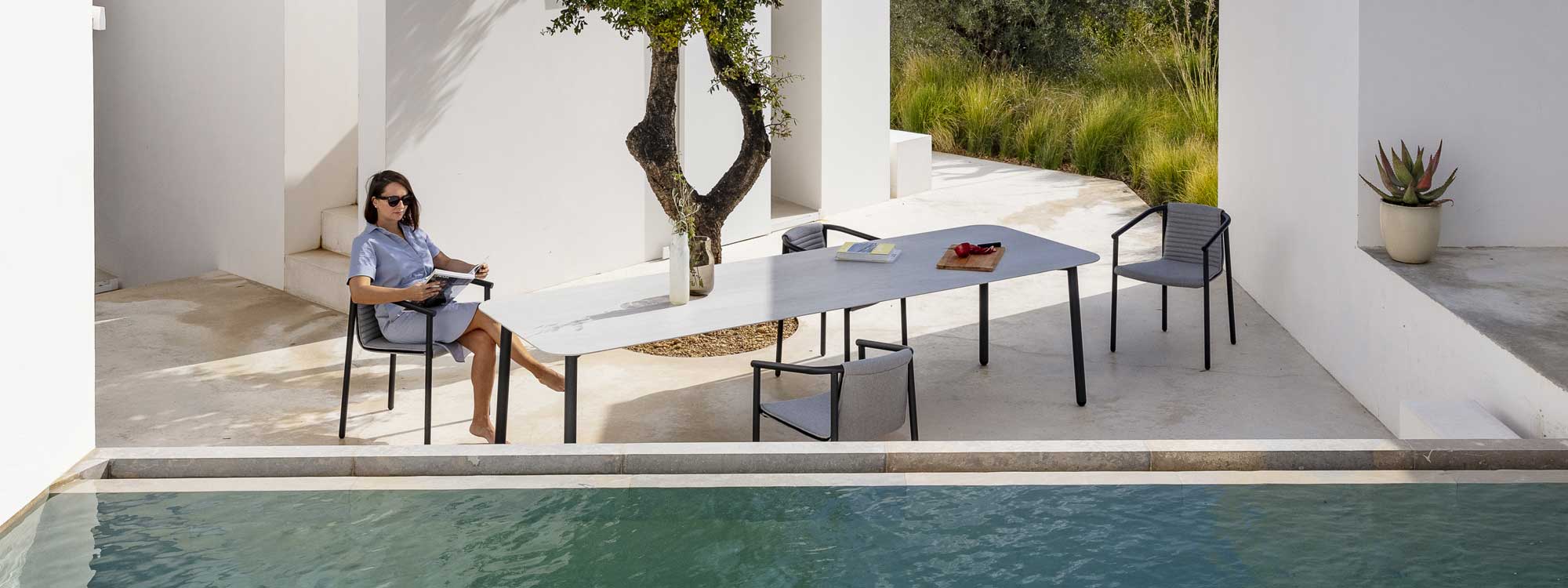 Image of birdseye view of Duct Round outdoor dining chair and Starling garden table between olive tree and swimming pool