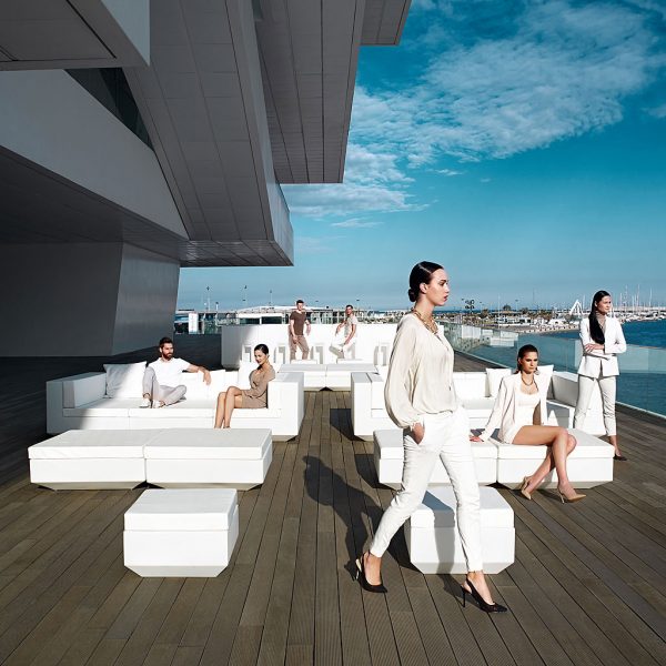 Image of young dudes sat around white Vela garden sofas on decking at America's Cup Foredeck building