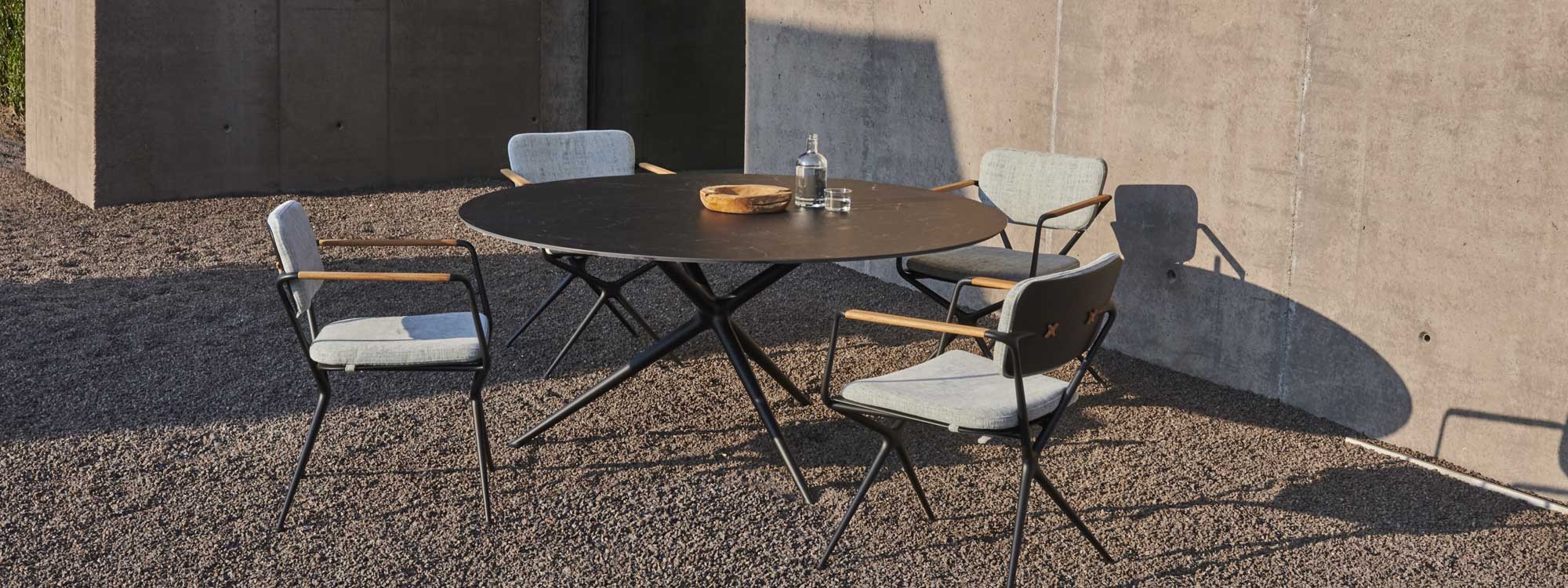 Image of Exes circular garden table with dark marble-effect ceramic top & Exes chairs by Royal Botania