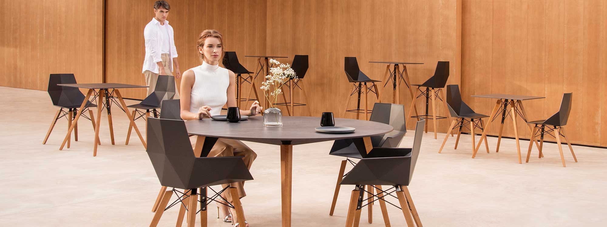 Image of woman sat at Vondom Faz Wood modern dining furniture with beech legs and black surfaces