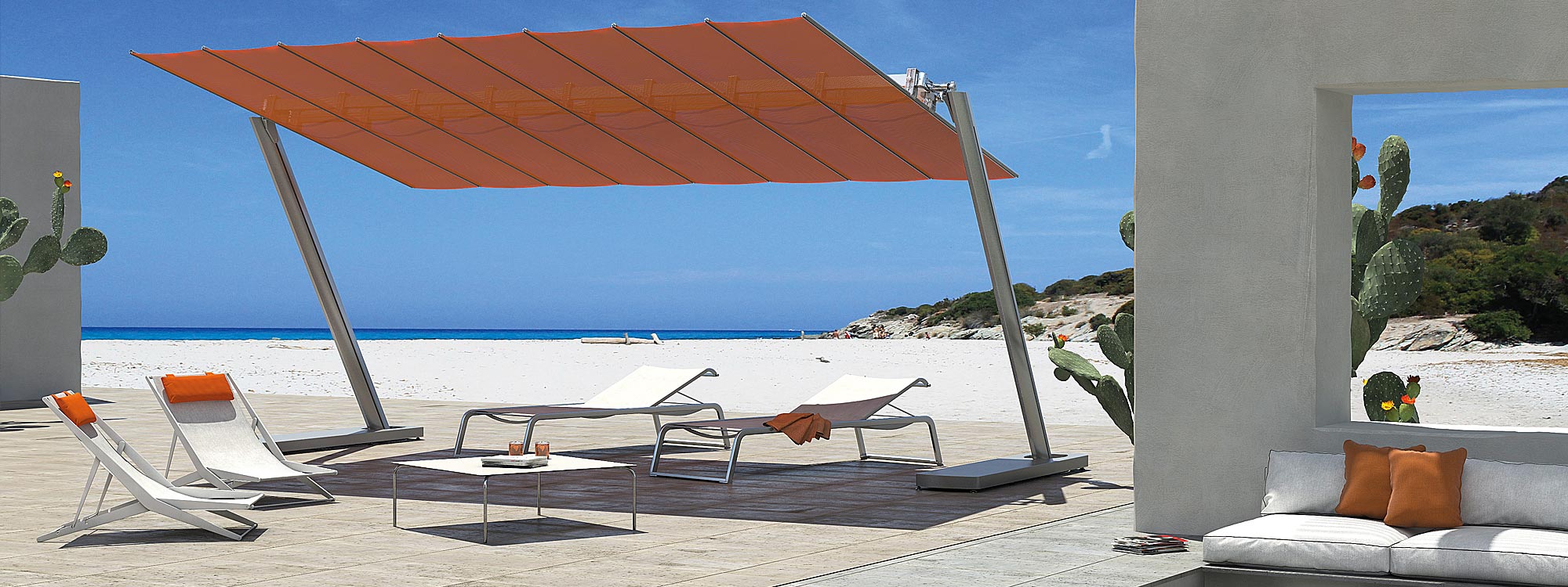 Orange Flexy Zen retractable awning shading Coro L3 loungers and Boomy folding chairs. Shown on decking on hot and sandy beach.
