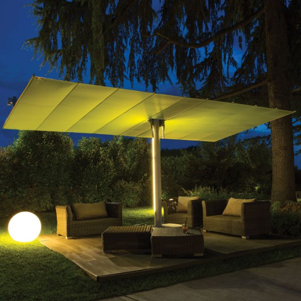 Image of illuminated FIM Flexy Twin free-standing sun shade at nighttime, shown in garden with lounge furniture beneath the canopies