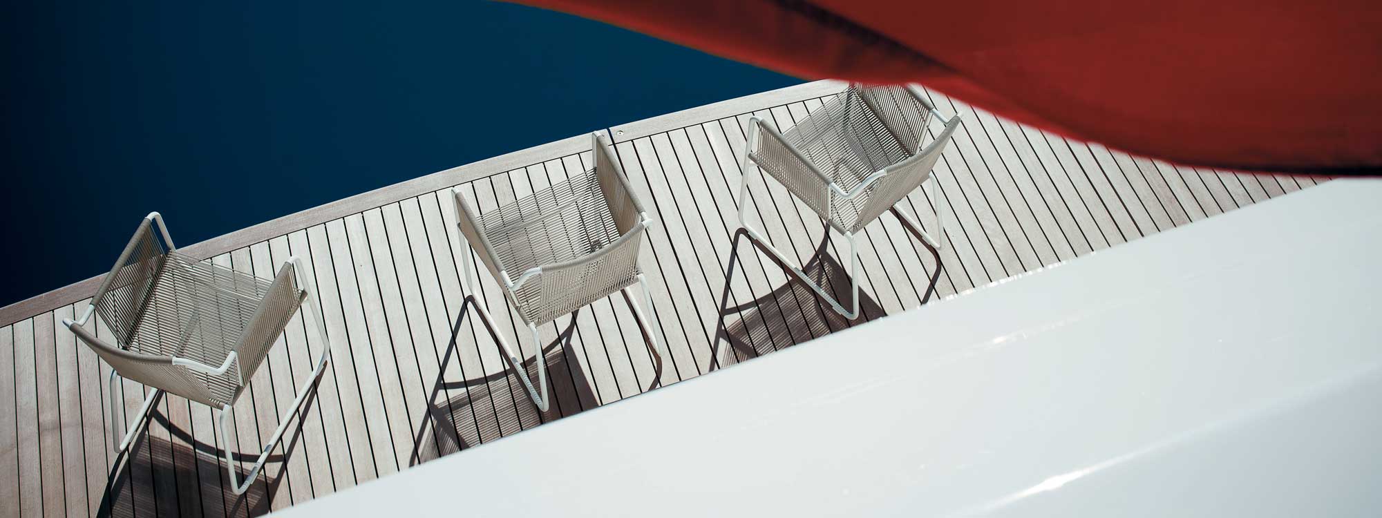 Image of 3 RODA Harp outdoor carver chairs with White frames and Sand cord, shown on decking by azure swimming pool
