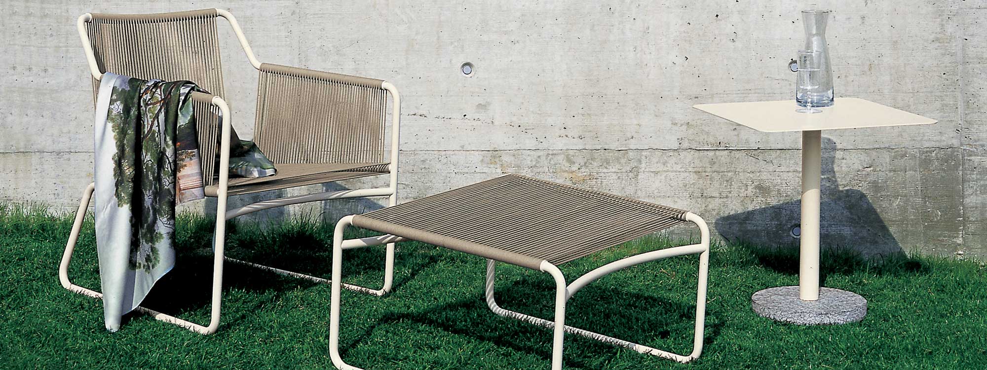 Image of RODA Harp outdoor lounge chair & footstool with Bernardo side table on lawn