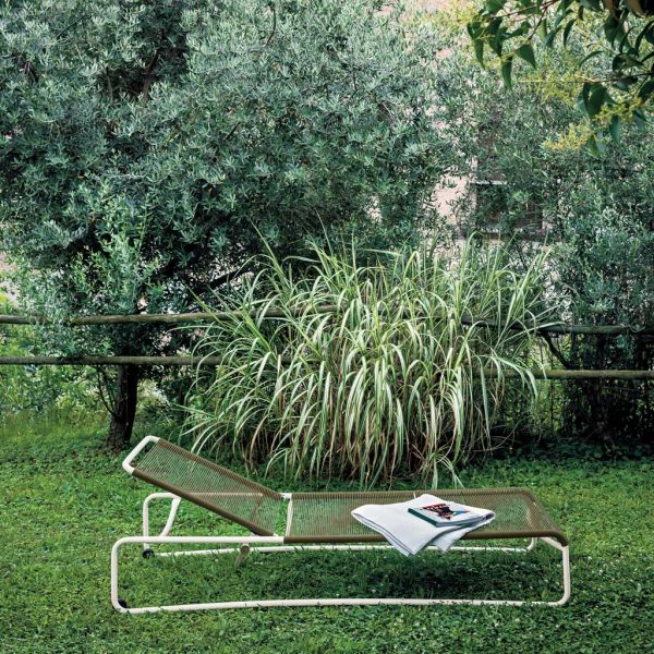Image of RODA Harp lettino with white frame and sand colored rope seat and back, shown on lawn with trees and shrubs in background