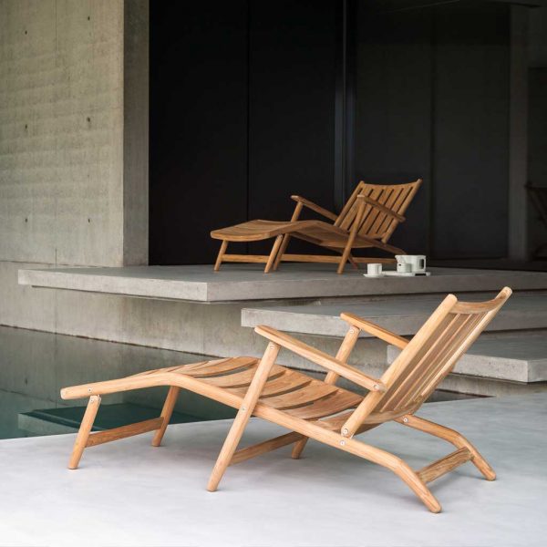 Image of pair of RODA Levante teak lounge chair with foot rest on interior poolside