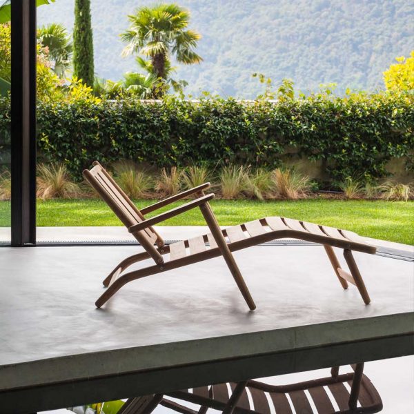 Levante contemporary steamer chair on polished concrete poolside with Italian countryside in background